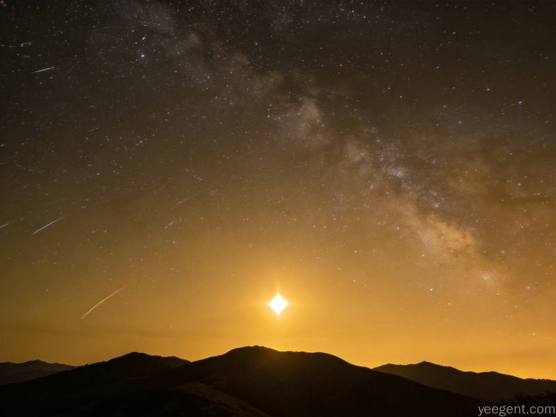 黎明前的东方夜空，金星明亮如钻石悬于天际，山峦剪影与银河星轨相映